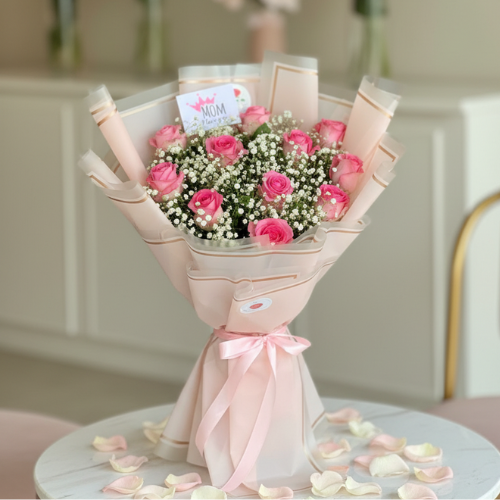 Mother’s Day pink roses bouquet wrapped in pastel pink paper with baby’s breath